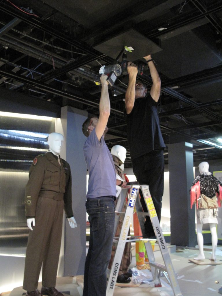 Scott Winston, Assistant Registrar and Carey Ward, Registrar, fixing wooden boards to the ceiling from which the jackets were suspended with four lengths of steel wire